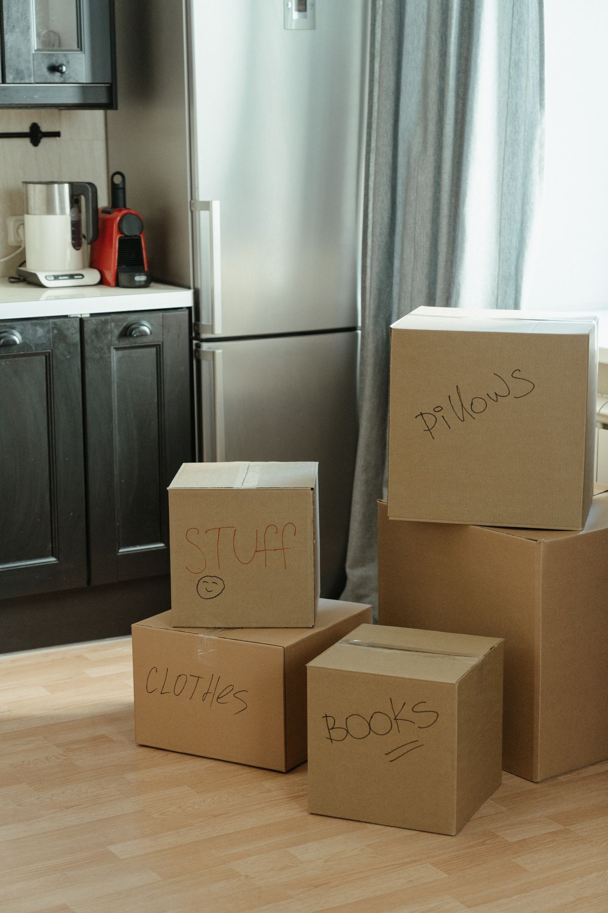 Labeled cardboard moving boxes in an apartment kitchen