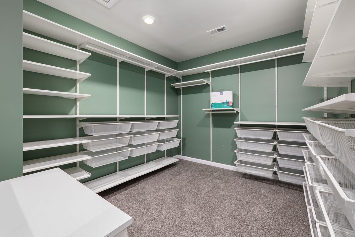 An organized walk-in closet with modern shelving